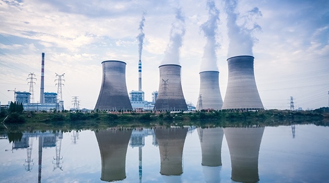 Nuclear power plant cooling towers reflected in water